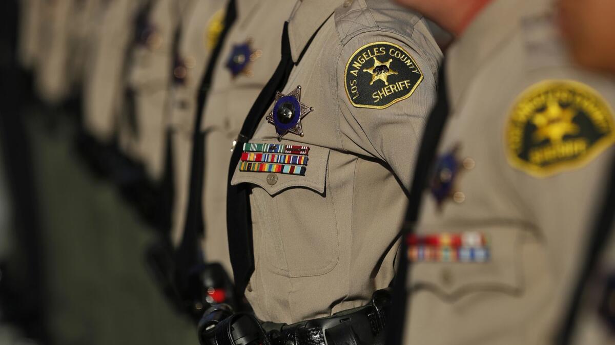 A tight shot of a shoulder patch on a deputy in a long line of others. 