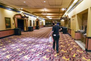 A worker with cleaning supplies heads to one of the theatres to prepare it for one of the first showings at the AMC theatre when it re-opened for the first time since shutting down when at the start of the COVID-19 pandemic, Thursday, Aug. 20, 2020, in West Homestead, Pa. (AP Photo/Keith Srakocic)
