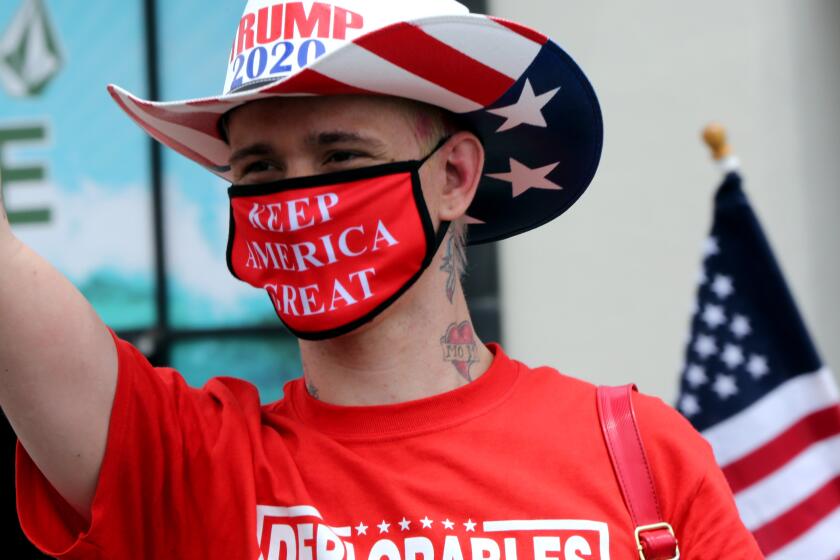 Kristopher Dreww, who calls himself an adorable deplorable, wears a Keep America Great mask during Saturday's protest.