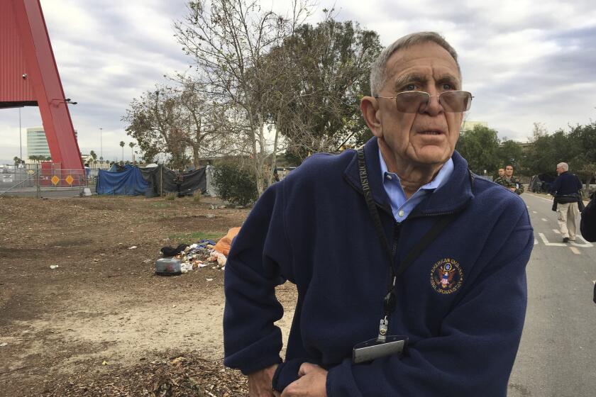 Judge David Carter, a U.S. District Judge, tours a Southern California homeless encampment in Santa Ana, Calif., Wednesday, Feb. 14, 2018. Judge Carter demanded that Orange County officials provide answers about what federal funding is available to feed and temporarily house people if they are moved. (AP Photo/Amy Taxin)