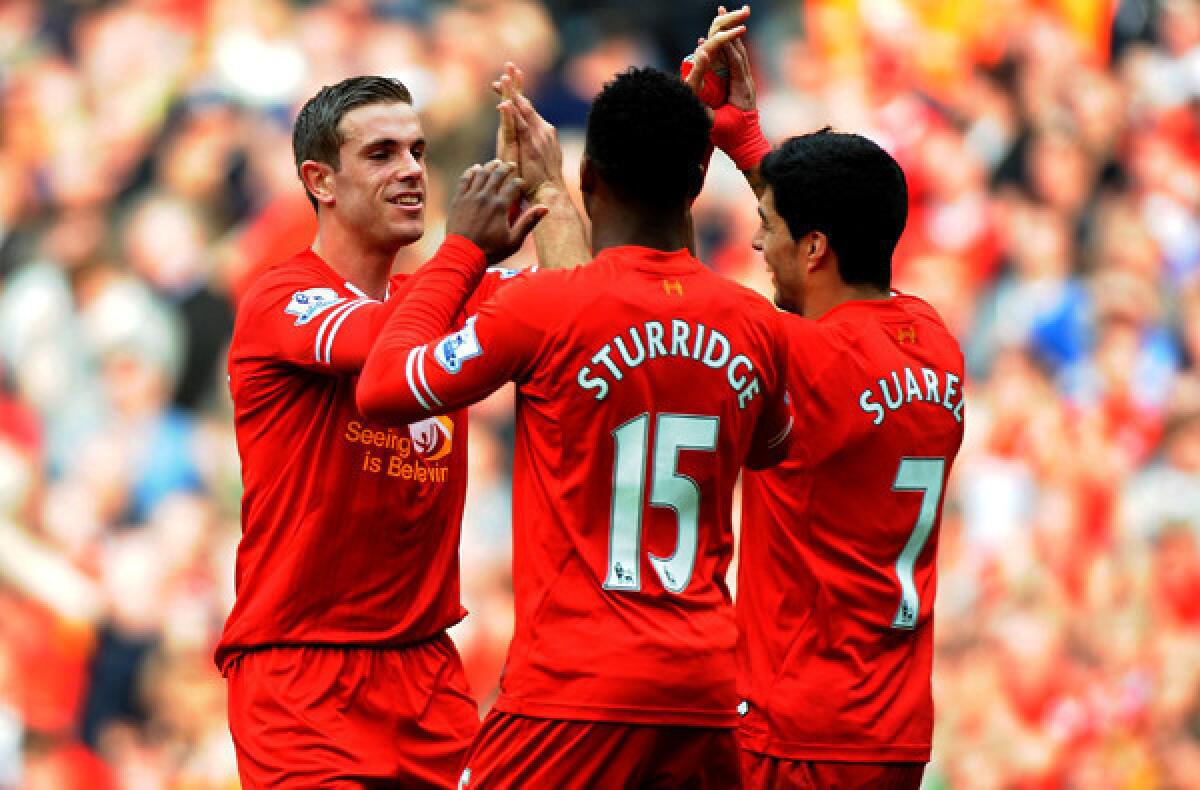 Liverpool's Jordan Henderson, left, is congratulated by teammates Daniel Sturridge and Luis Suarez after scoring a goal against Tottenham. The Reds have plenty to cheer about in leading the English Premier League standings if not in star power.