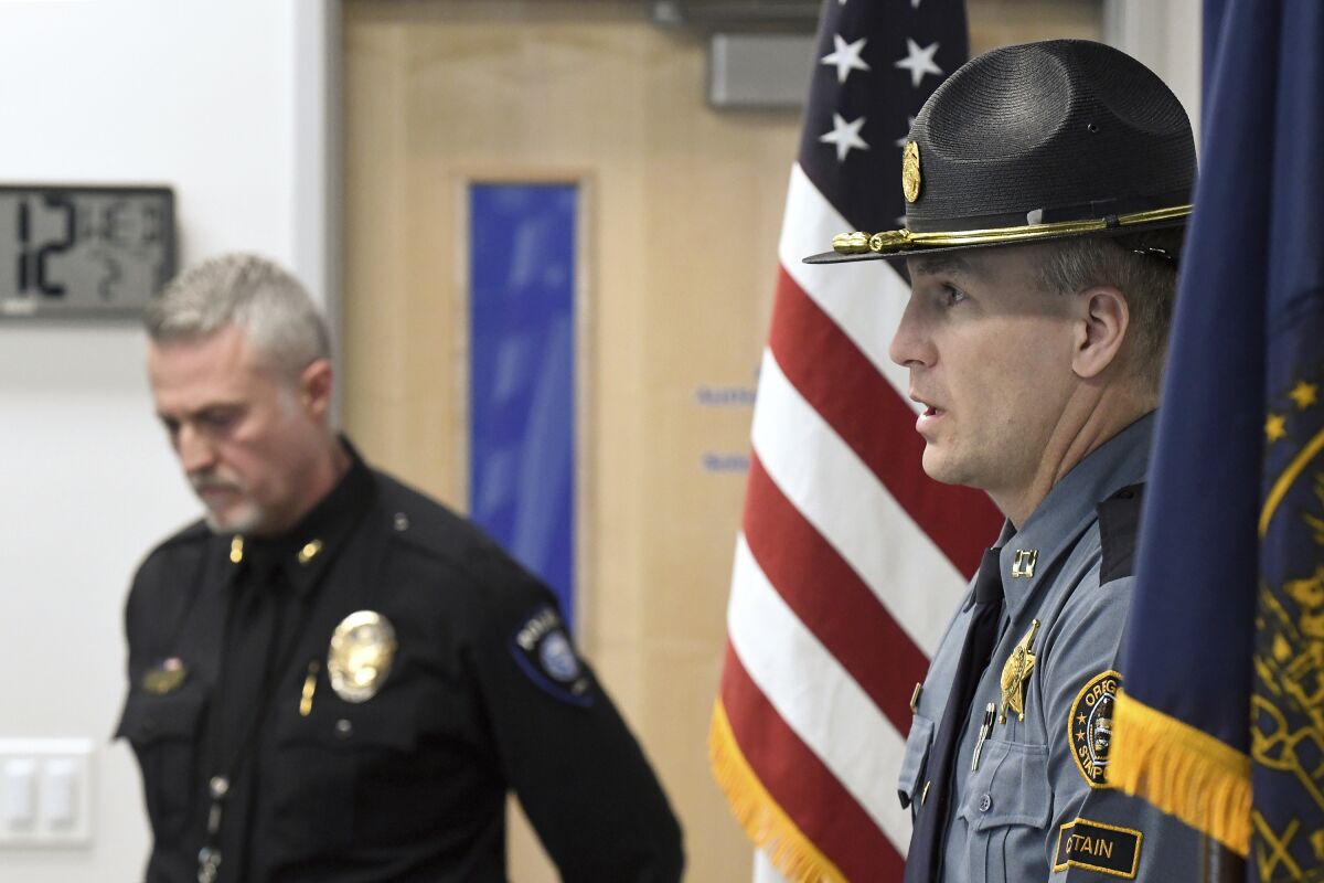 Oregon State Police, Capt. Kyle Kennedy, right, speaks to reporters during a news conference at Grants Pass police headquarters on Wednesday, Feb. 1, 2023, in Grants Pass, Ore. Kennedy, and Grants Pass Police Chief Warren Hensman, left, recounted the series of events in recent days that led to an armed standoff with a suspect in a violent kidnapping in Oregon who died after shooting himself, authorities said. Police now believe he also murdered two people in Sunny Valley, Ore. (Scott Stoddard/Grants Pass Daily Courier via AP)