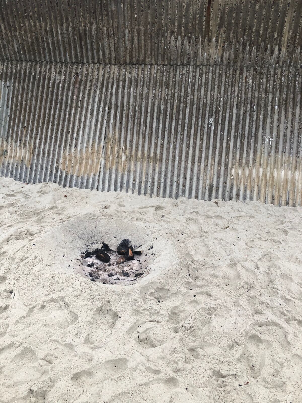 Burnt coals are pictured in the sand at Marine Street Beach.