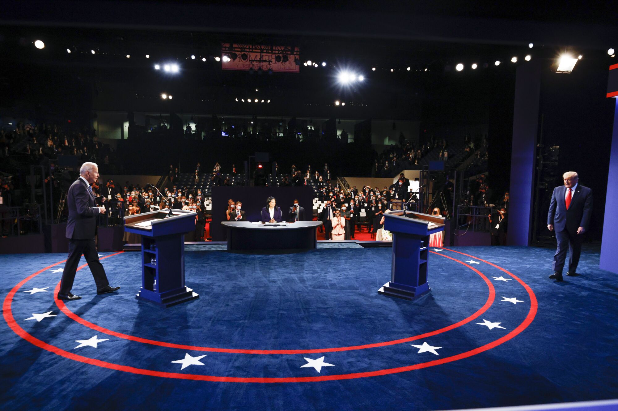 President Trump and Joe Biden walk onto a blue carpeted debate stage