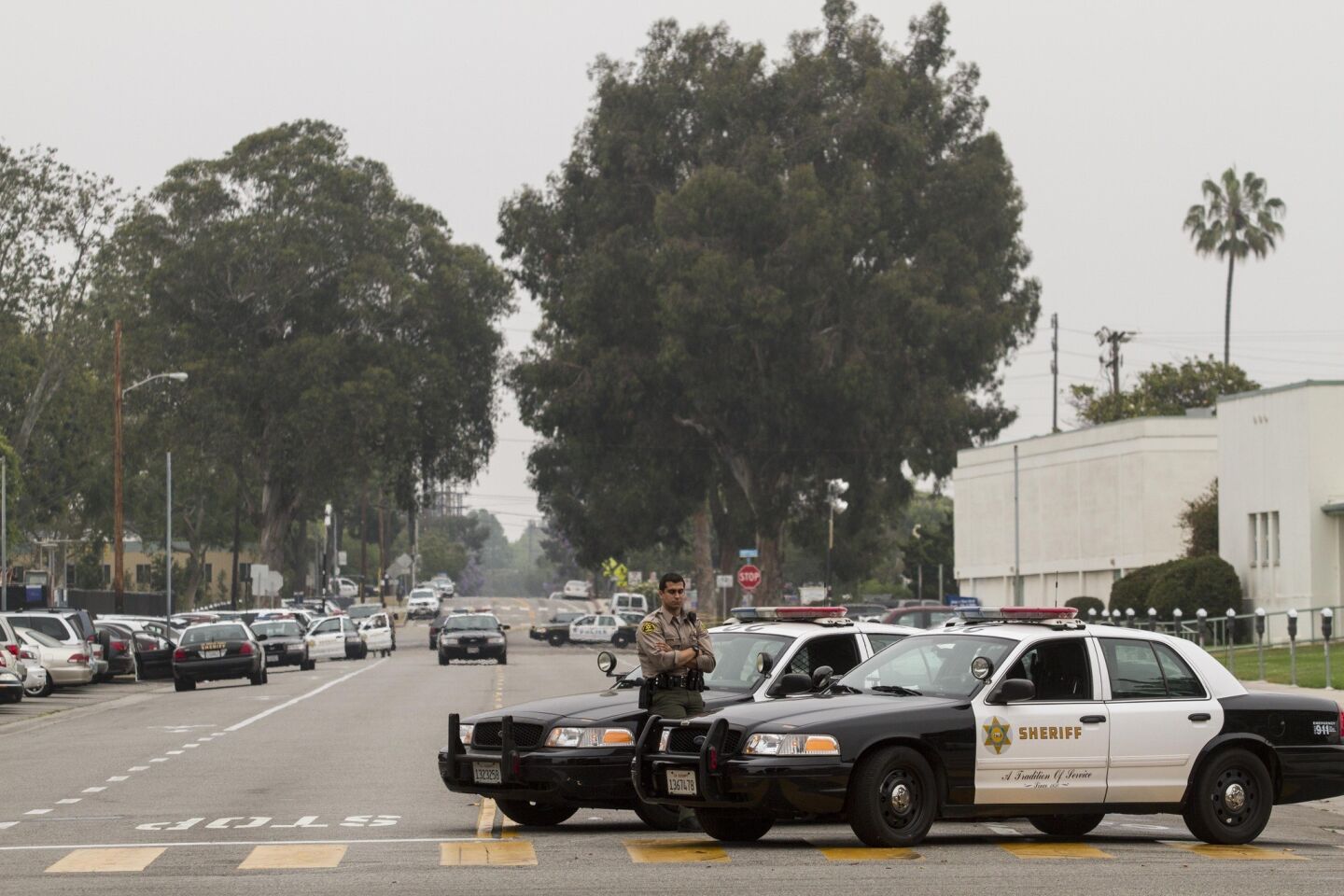 A Los Angeles County sheriff's deputy stands Saturday morning near one of the crime scenes from a deadly shooting rampage that ended at Santa Monica College on Friday.