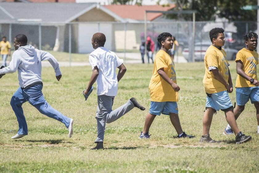 TORRANCE CA APRIL 22, 2019 -- Students at Magnolia Science Academy 3, left, pass students from Curtiss Elementary School, in yellow, during physical education class on the campus of Curtiss Middle School in Carson on Monday April 22, 2019. Magnolia Science Academy 3, a charter school operating one the Curtiss campus is hoping to use some of the school's unused classrooms for their students. (Photo by Nick Agro / For The Times)