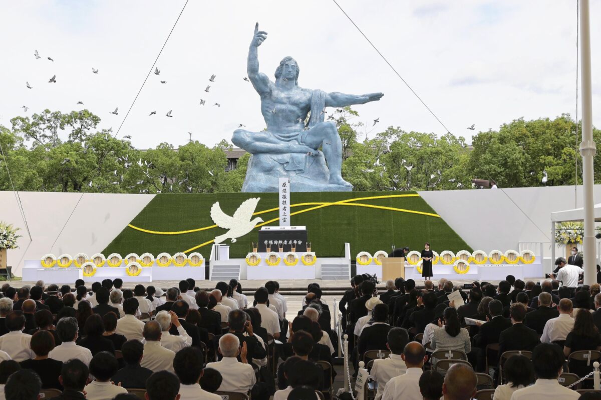 Doves fly over the Peace Statue during a ceremony to mark the 77th anniversary of the U.S. atomic bombing at the Peace Park in Nagasaki, southern Japan, Tuesday, Aug. 9, 2022. (Kyodo News via AP)