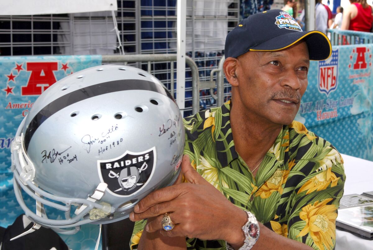 Raiders legend Willie Brown holds an autographed Raiders helmet while attending the Pro Bowl in Hawaii in 2006.