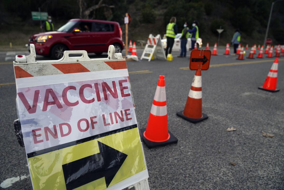 Drivers enter a mega COVID-19 vaccination site set up in the parking lot of Dodger Stadium.