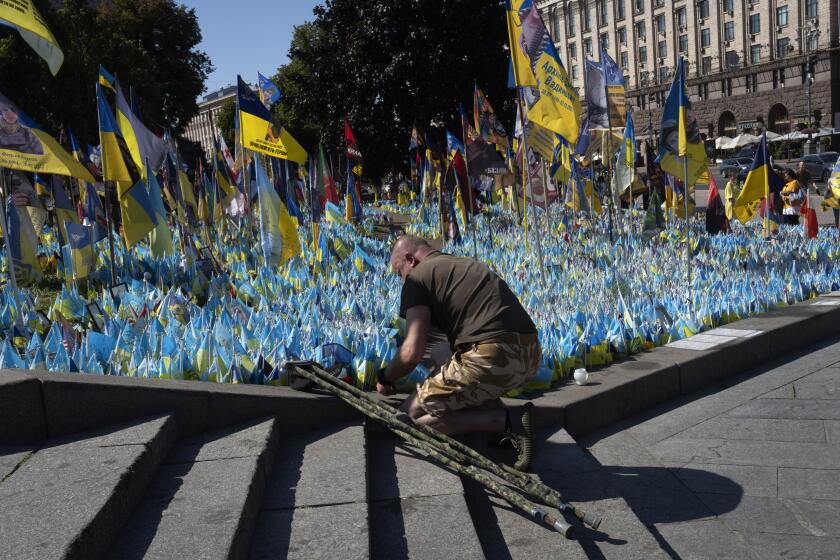 A veteran pays his respect at a makeshift memorial for fallen Ukrainian soldiers during the Ukrainian Independence Day on Independence Square in Kyiv, Ukraine, Saturday, Aug. 24, 2024. (AP Photo/Efrem Lukatsky)