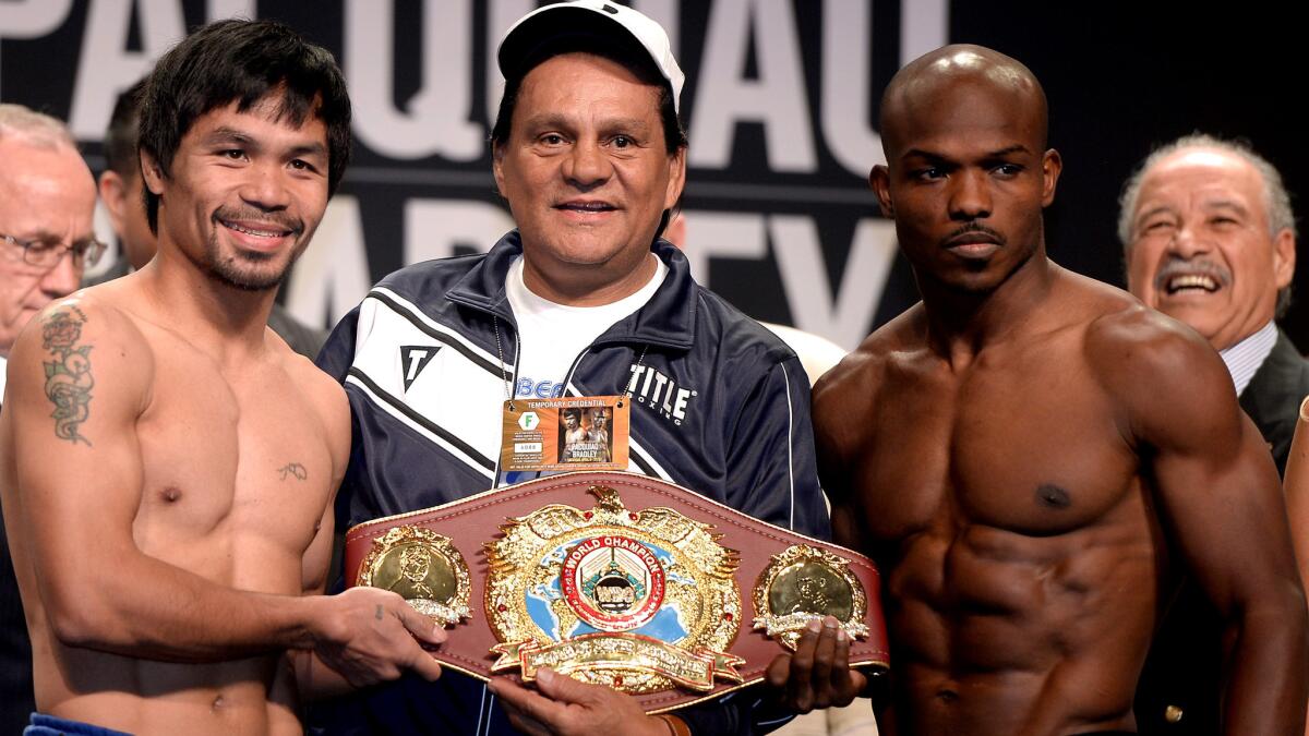 Former boxing champion Roberto Duran poses between Manny Pacquiao, left, and Timothy Bradley after their weigh-in Friday.