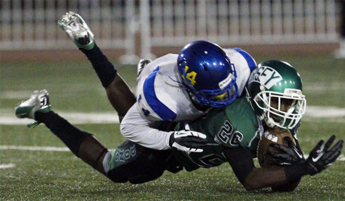 Crenshaw cornerback Mossi Johnson tackles Dorsey wide receiver Joshua Hill in a 2012 game. Johnson enrolled early at UCLA.