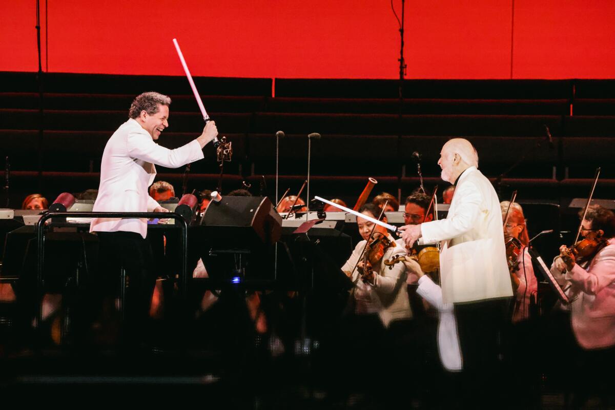 Gustavo Dudamel and John Williams fight with lightsabers at the Hollywood Bowl Sunday, July 9