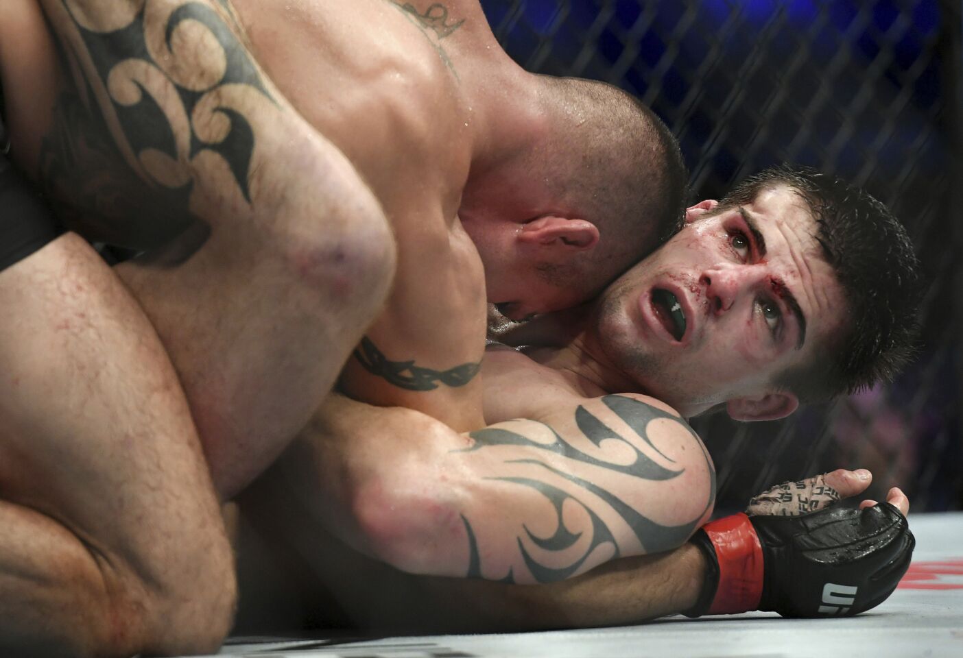 Craig White, right, is held down by Diego Sanchez during their UFC welterweight mixed martial arts bout at UFC 228 on Saturday, Sept. 8, 2018, in Dallas. (AP Photo/Jeffrey McWhorter)