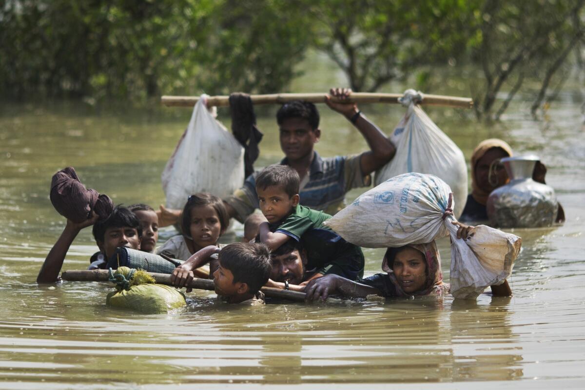 A Rohingya family fleeing Myanmar crosses a creek of the Naf river to reach the border with Bangladesh.