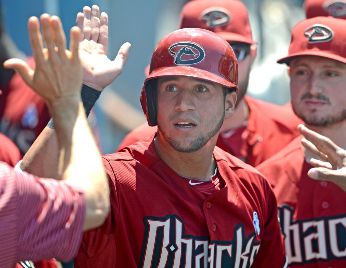 Arizona's David Peralta is congratulated by his teammates after scoring on a wild pitch by Josh Beckett during the fifth inning of the Dodgers' 6-3 loss to the Diamondbacks.