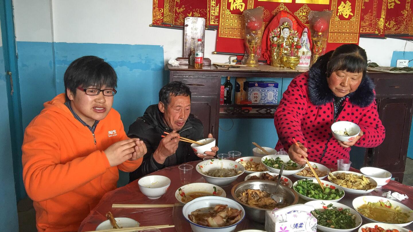 Rural Taobao partner Luo Rong eats lunch with his parents at their home in Yufeng village.