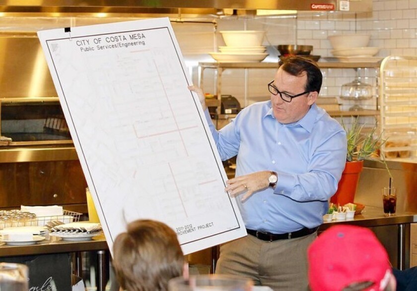 Mayor Jim Righeimer holds up and shows a Costa Mesa street improvement map during Meet the Mayor session at Pitfire Artisan Pizza on Thursday.