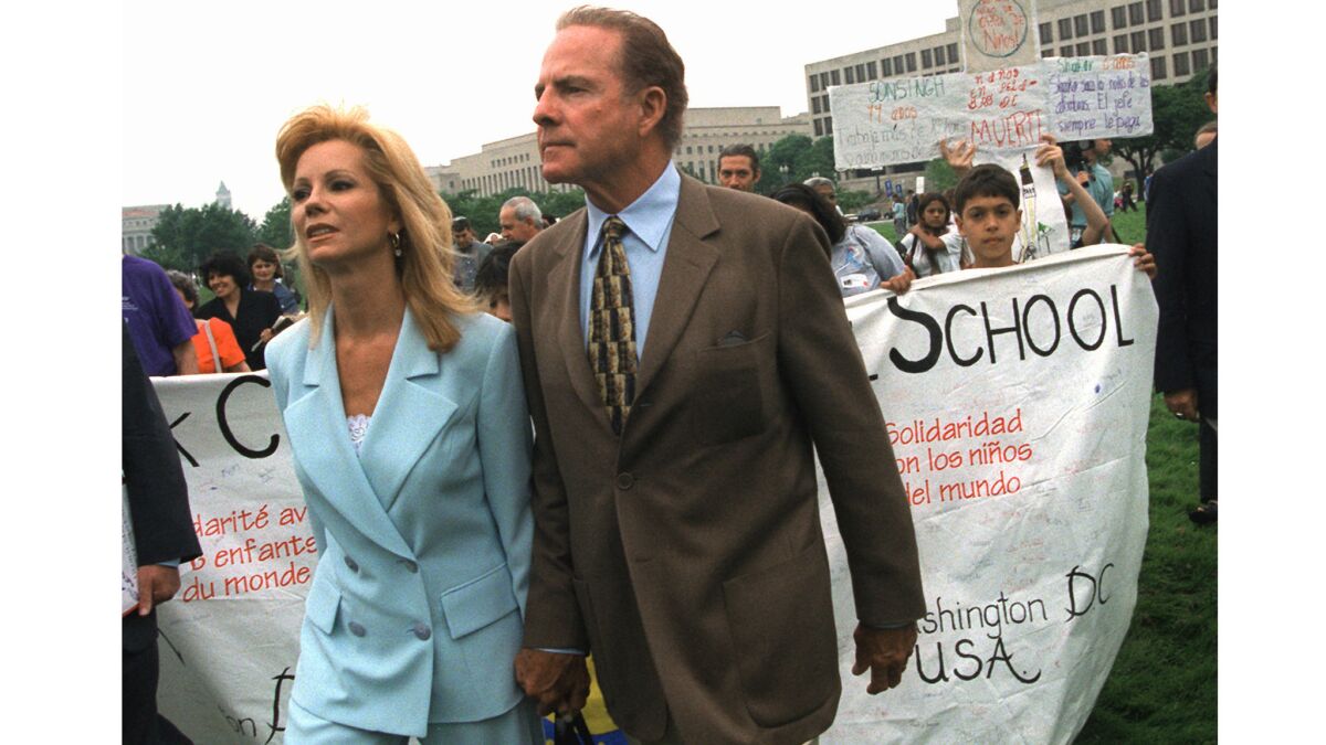 Hand in hand, Kathie Lee Gifford and her husband Frank Gifford leave a May 1998 rally in Washington, D.C., against child labor. Their activism was sparked by a scandal a year earlier involving her Wal-Mart clothing line.