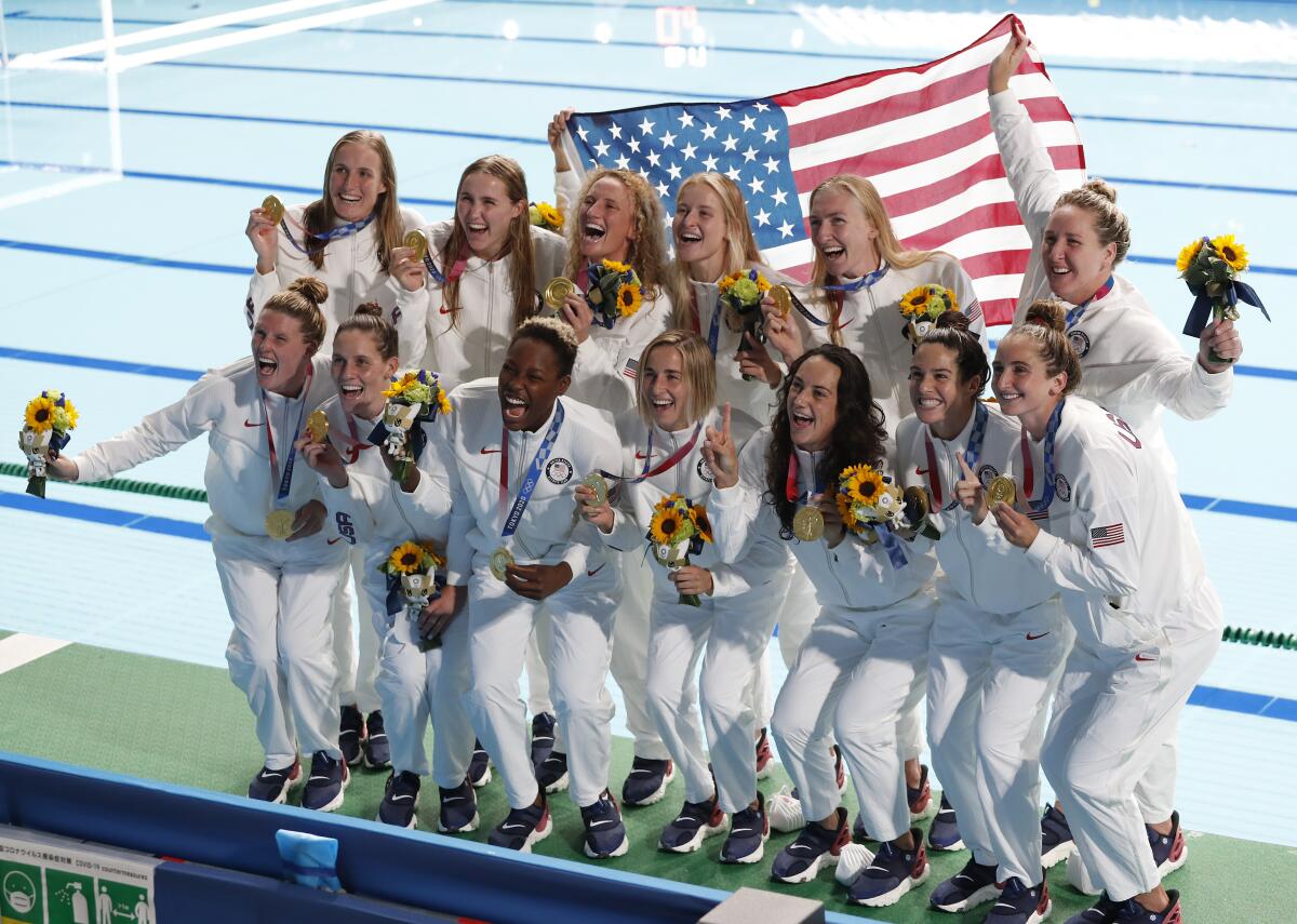 Members of the U.S. women's water polo team celebrate after receiving their gold medals Saturday in Japan.