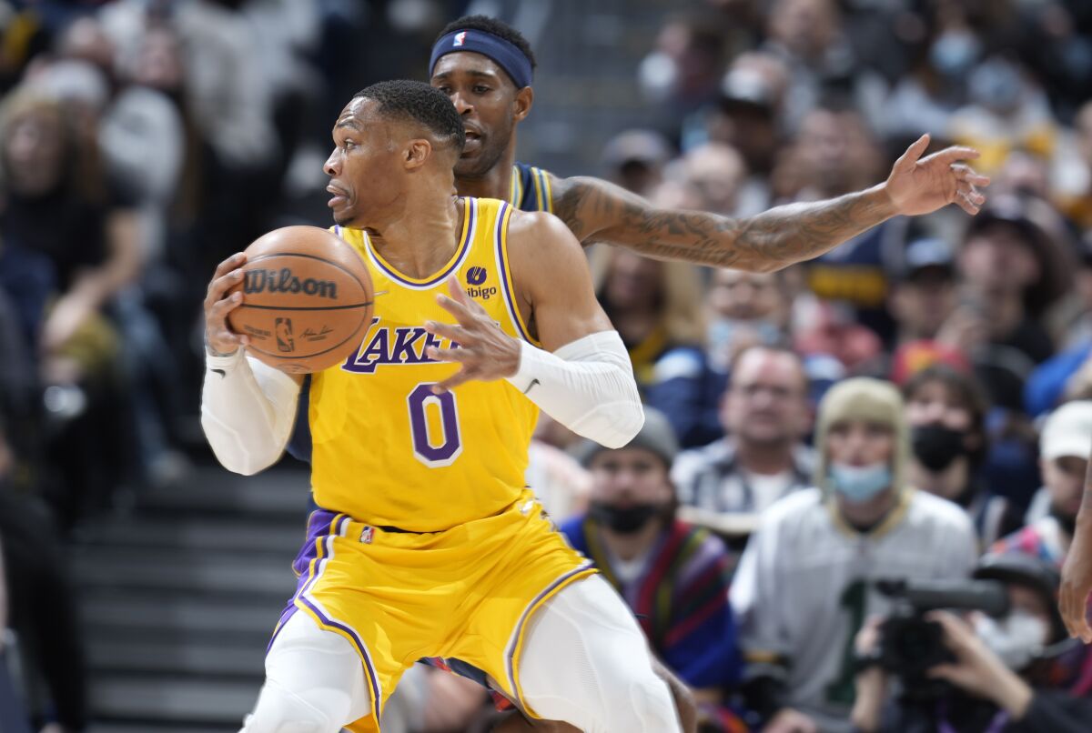 Russell Westbrook holds the ball and looks to the side.
