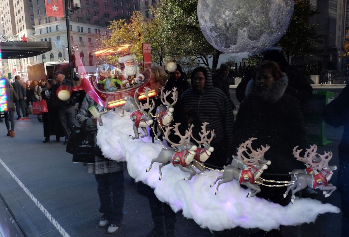 People are reflected on a store window decorated with a Santa Claus in New York City on Nov. 21.