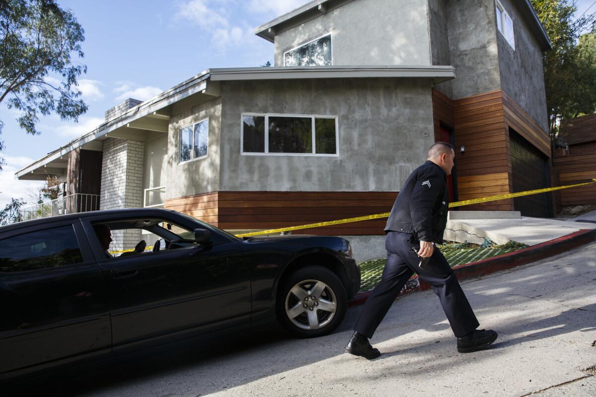 L.A. police officers wait for a search warrant outside of a home during a fatal shooting investigation in Hollywood Hills on Monday. Police say 27-year-old Henry Estrada was shot dead just after 8:30 p.m. Sunday at a residence in the 2000 block of Sycamore Avenue.