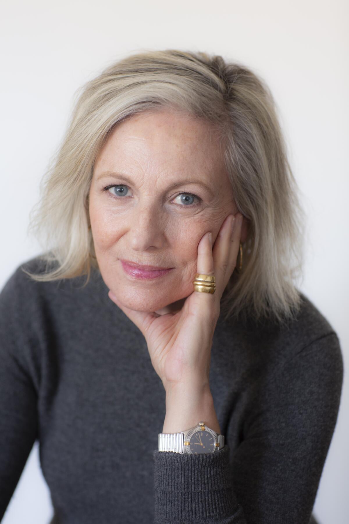 A headshot of a woman in a dark gray sweater