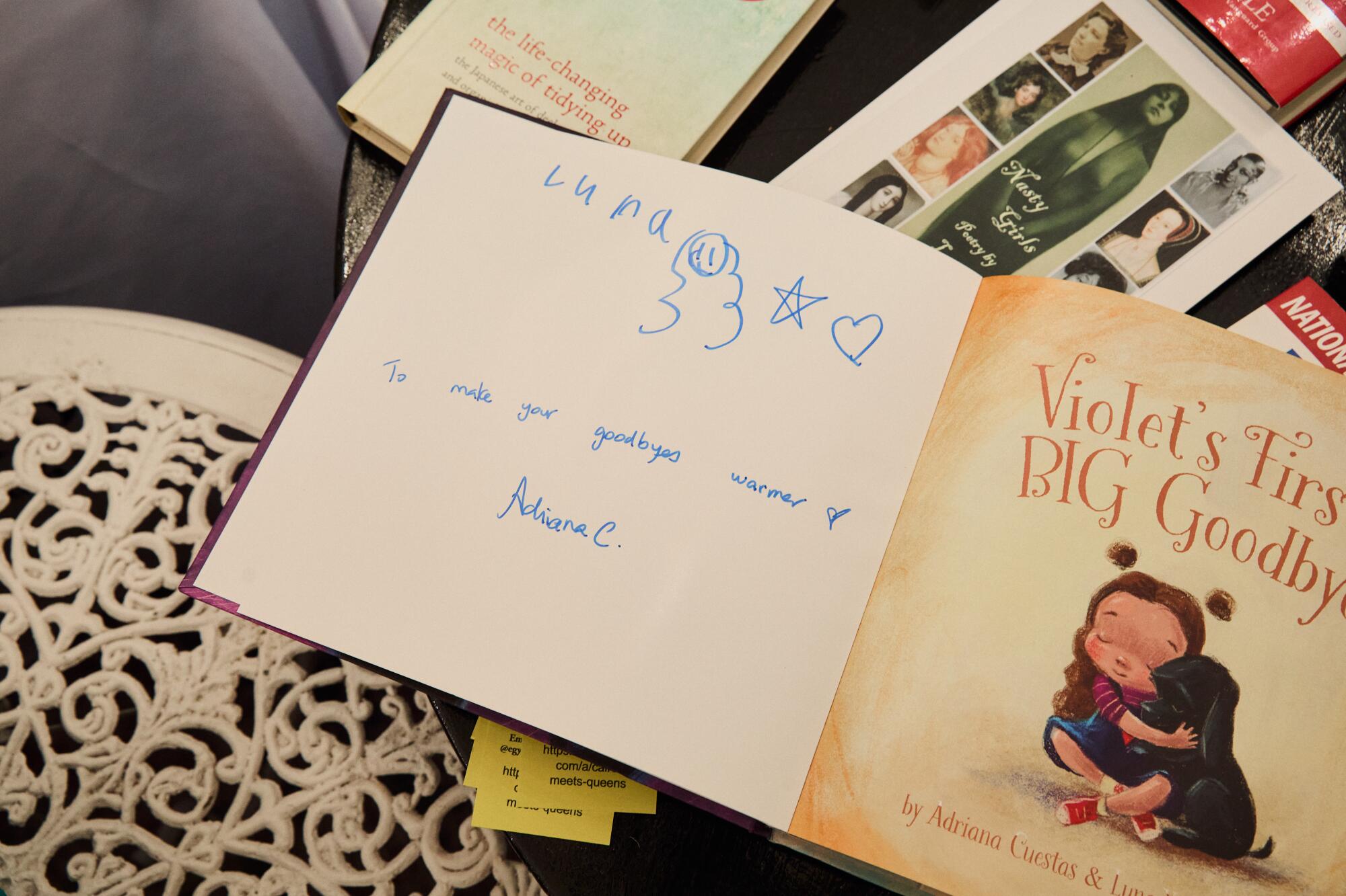 A signed copy of "Violet's First Big Goodbye" by Luna Yanez-Cuestas lies on a table at the Libros bookshop.