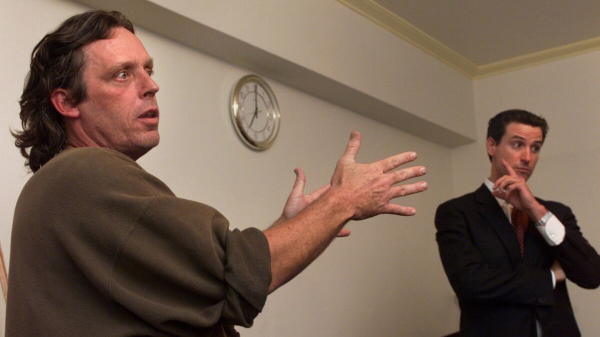 Paul Boden, left, a San Francisco advocate for the homeless, debates then-Supervisor Gavin Newsom during a meeting of Democrats in San Francisco in 2002.