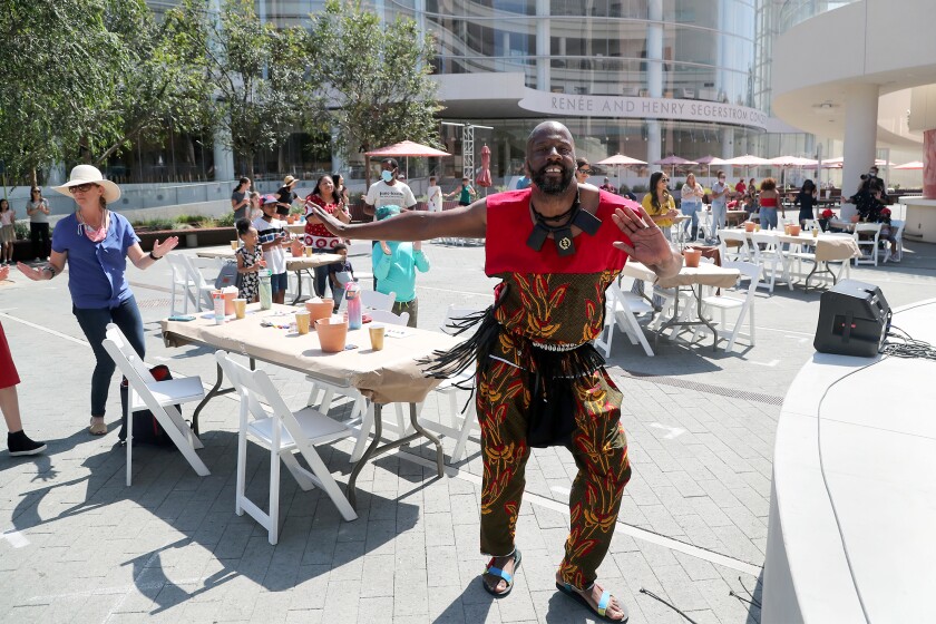 A member of the Dembrebrah Drum and Dance Ensemble joins visitors as he performs on Saturday.