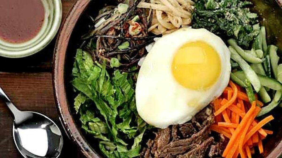 LOOKING SUNNY: Bibimbap with spinach, cucumber, carrots, beef, romaine, fernbrake and bellflower root, topped with a fried egg.