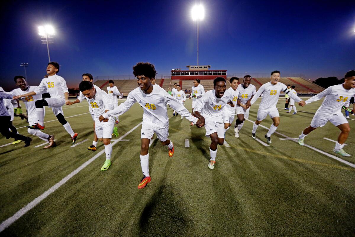 Margaret Long Wisdom High School soccer players run off the field towards fans, celebrating an undefeated season after a 6-2 win against Stephen Pool Waltrip High School at Joe K. Butler Stadium in Houston, Texas, on March 20, 2017.