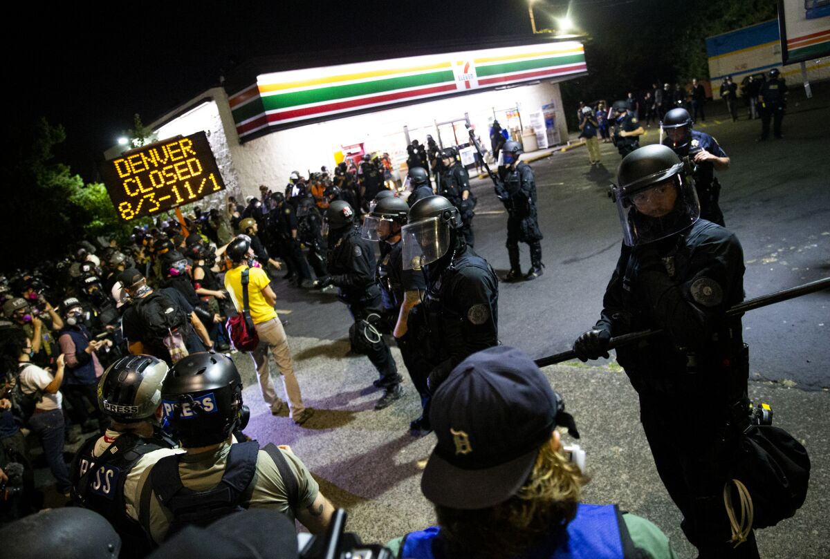 Protesters gather at Peninsula Park in north Portland, Ore., on their way to the Portland Police Association building late Tuesday, Aug. 4, 2020. A riot was declared early Wednesday during demonstrations in Portland after authorities said people set fires and barricaded public roadways.(Dave Killen /The Oregonian via AP)