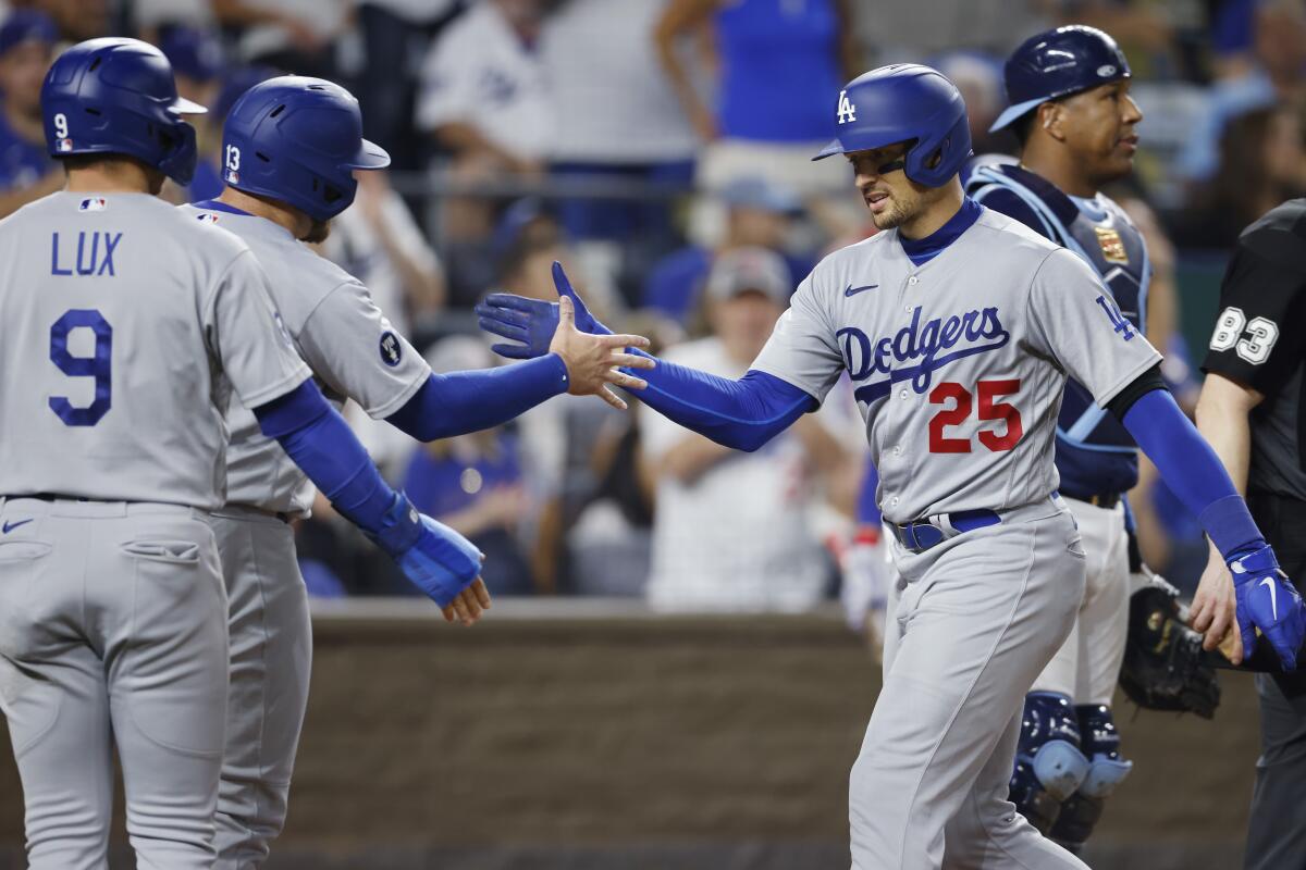Trayce Thompson, right, is congratulated by Gavin Lux (9) and Max Muncy.