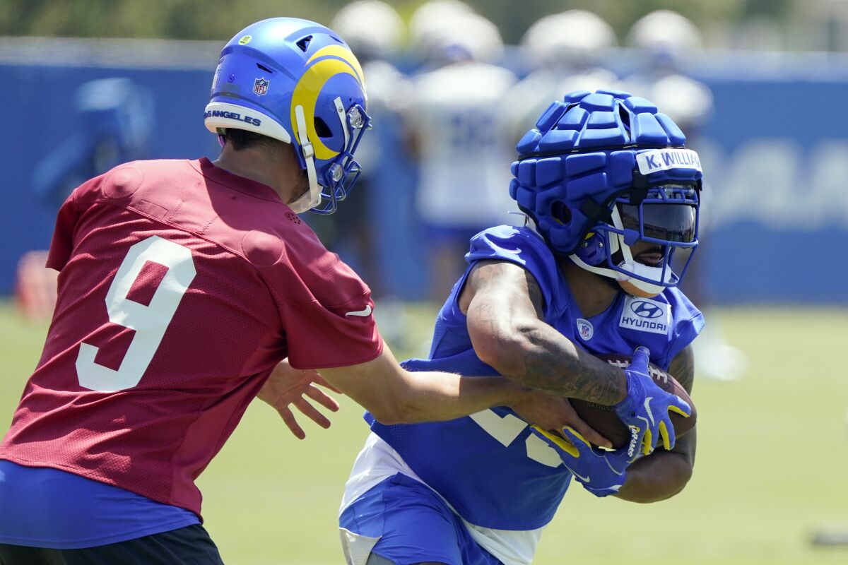 Rams running back Kyren Williams, right, gets a hand off from quarterback Matthew Stafford during practice in May.