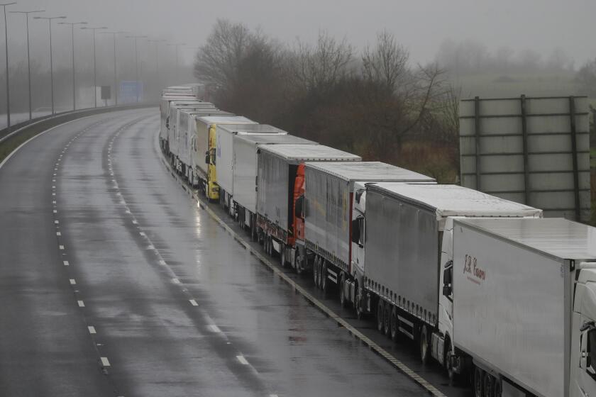 Lorries parked on the M20 near Folkestone, England, Monday, Dec. 21, 2020, as part of Operation Stack after the Port of Dover was closed and access to the Eurotunnel terminal suspended following the French government's announcement. France banned all travel from the UK for 48 hours from midnight Sunday, including trucks carrying freight through the tunnel under the English Channel or from the port of Dover on England's south coast. (AP Photo/Kirsty Wigglesworth)