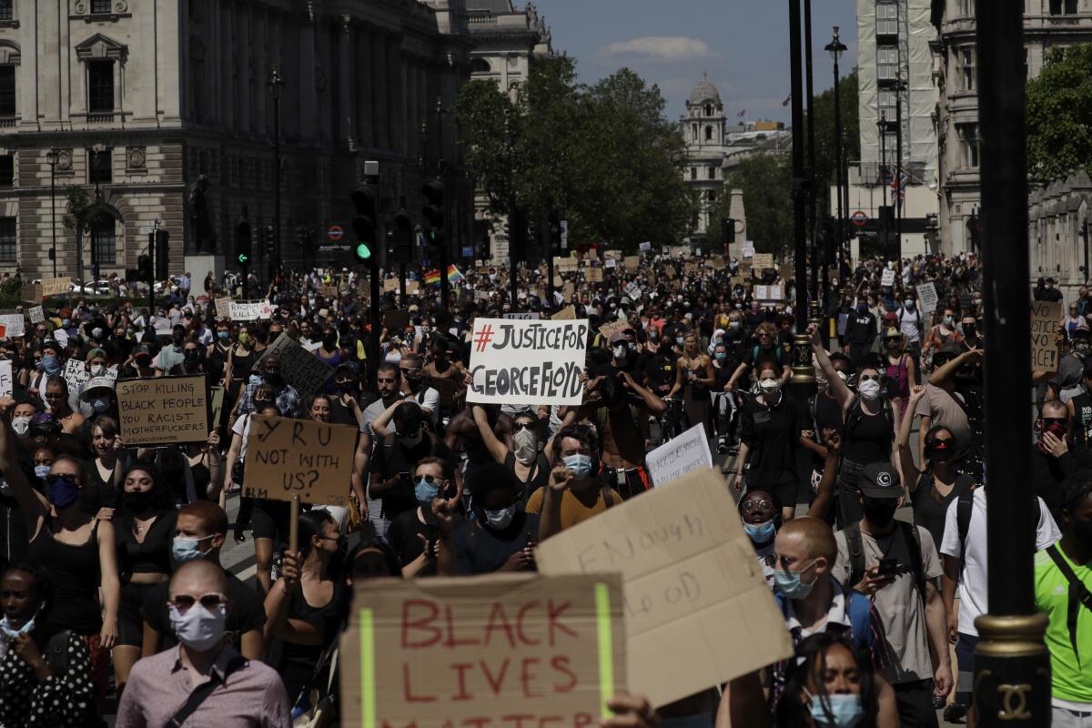Cientos de personas marchan hacia Parliament Square en el centro de Londres, el domingo 31 de mayo de 2020, en una protesta por la muerte del afroestadounidense George Floyd causada por un policía en Minneapolis, Minnesota. (AP Foto/Matt Dunham)