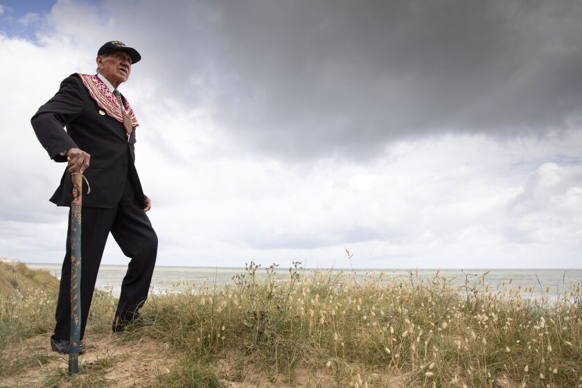 World War II D-Day veteran and Penobscot Elder from Maine, Charles Norman Shay poses on the dune overlooking Omaha Beach prior to a ceremony at his memorial in Saint-Laurent-sur-Mer, Normandy, France, Friday, June 5, 2020. Saturday's anniversary of D-Day will be one of the loneliest remembrances ever, as the coronavirus pandemic is keeping almost everyone away, from government leaders to frail veterans who might not get another chance for a final farewell to their unlucky comrades. (AP Photo/Virginia Mayo)