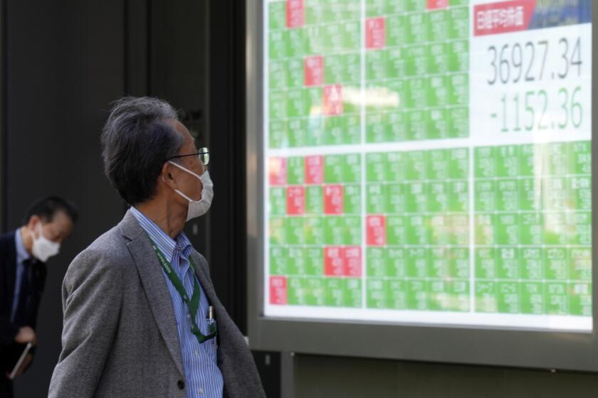 FILE - A person looks at an electronic stock board showing Japan's Nikkei 225 index at a securities firm in Tokyo, on April 19, 2024. Asian benchmarks extended gains Tuesday, April 23, after U.S. stocks clawed back a chunk of their losses from the previous week.(AP Photo/Eugene Hoshiko, File)