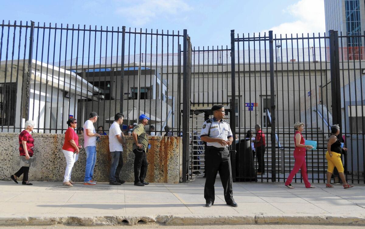 Cubans wait in line outside the U.S. "interests section" compound in Havana to apply for visas.