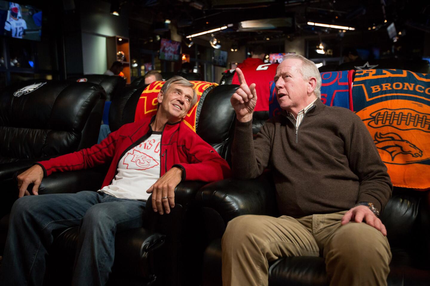 Doug Smith, father of Chiefs quarterback Alex Smith, left, and Archie Manning, father of Giants quarterback Eli Manning and Broncos quarterback Peyton Manning, right, talk during halftime of the Chiefs/Broncos game.