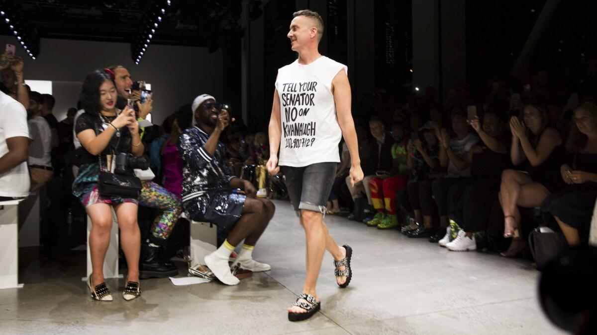 For his runway finale walk, Jeremy Scott wears a T-shirt reading, "Tell your senator no on Kavanaugh," a reference to the current Supreme Court nominee whose confirmation hearings are currently underway.