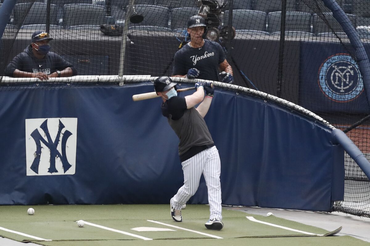 New York Yankees hitting coach Marcus Thames, left, and Aaron Judge, right, watch Clint Frazier bat in the cage during a summer training camp workout, Wednesday, July 8, 2020, at Yankee Stadium in New York. (AP Photo/Kathy Willens)