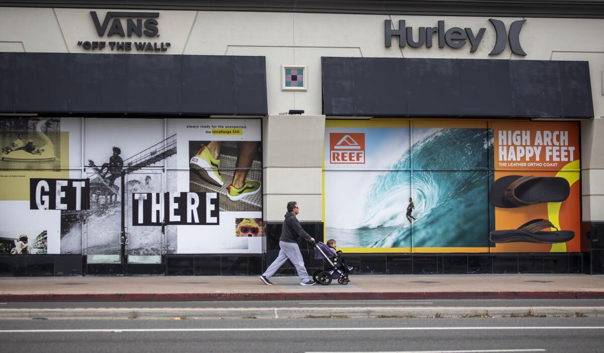 A man takes his child on a walk in downtown Huntington Beach amid coronavirus restrictions last week. 