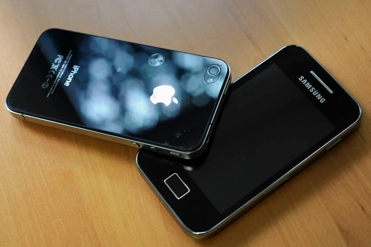 A Samsung phone right next to an Apple iPhone 4.