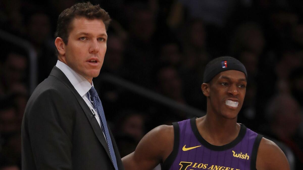 Lakers head coach Luke Walton talks with guard Rajon Rondo.