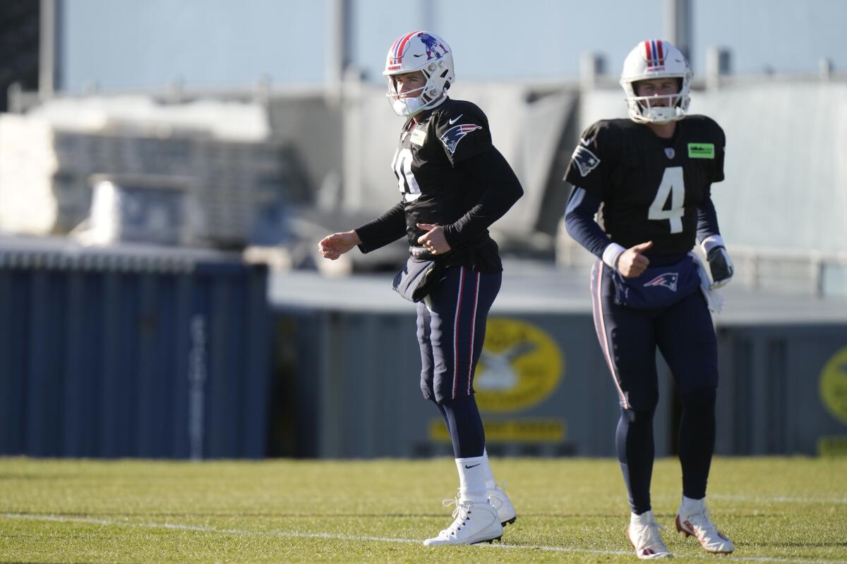 Patriots quarterbacks Mac Jones (10) and Bailey Zappe (4) warm up during practice Wednesday.