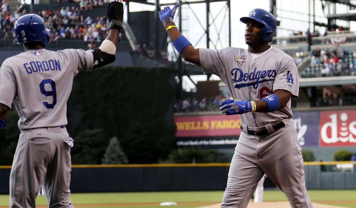 Dodgers second baseman Dee Gordon congratulates right fielder Yasiel Puig after he hit a two-run home run against the Colorado Rockies in the first inning Friday in Denver.