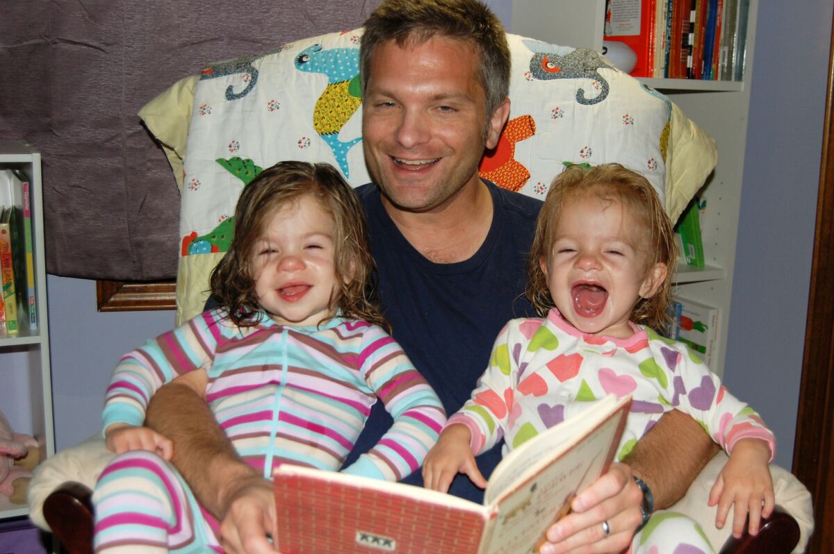 Mike Brandfon of Chicago reads to his twin daughters in 2012, when he was a stay-at-home dad after losing his job in 2009. Once the girls were nearing 3, he began looking for work again and landed a job last September.